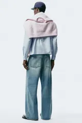 Jeans de cinco bolsillos en denim de algodón rígido, color celeste claro con efecto desgastado. Modelo de corte holgado de cadera a bajo con pierna amplia y tiro caído.