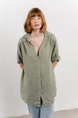 Camisa color beige de lino, con corte recto y calce suelto, cuello camisero, botones en el frente y mangas cortas con presilla y botón.