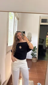 Remera negra de algodón con cuello bote y escudo de Uruguay bordado en dorado.