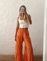 Pantalón palazzo naranja con elástico en la cintura y diseño escalonado con volados.