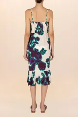 Vestido playero estampado con flores moradas y verdes, breteles finos y volados en el frente.