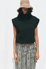 Pantalón de tiro alto con nudo delantero, de pernera ancha y estampado a rayas verticales en blanco y negro.
