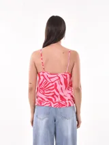 Musculosa blanca con breteles finos, escote en V y botones frontales.