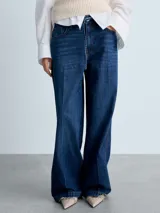 Pantalón de jean azul oscuro, de corte wide leg, tiro medio, con cinco bolsillos y cierre frontal con cremallera y botón.