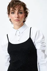 Vestido corto de lurex plateado y negro, sin mangas, con breteles finos regulables y volados tipo balloon desde la cadera.