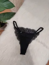 Tanga negra de encaje con tiras finas regulables.