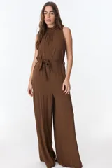 Mono largo color marrón con cuello alto, sin mangas y cinturón de lazo. Pantalón de pierna ancha.