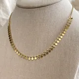 Collar de cadena en acero dorado con dijes en forma de círculo, diseño minimalista.