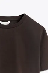 Camiseta de manga corta con cuello redondo, corte cropped y patrón de rayas horizontales en azul marino y blanco.