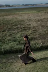 Pollera larga color beige con textura arrugada y abertura frontal.