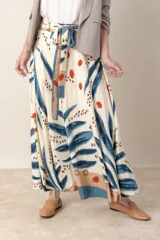 Pollera larga de viscosa color crudo con estampado de hojas azules y detalles en marrón y rojo.