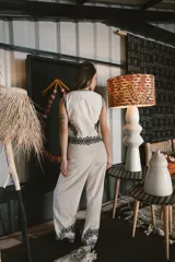 Pantalón de vestir color beige, de corte palazzo, con bordado de flores negras en el ruedo.