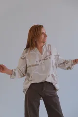 Camisa beige con estampado batik en tonos marrones, de corte holgado, cuello mao y mangas 3/4.