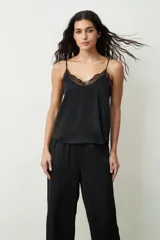 Blusa color crudo con lunares dorados, breteles finos y escote en V con detalle de encaje.