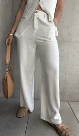 Pantalón de vestir color crudo, de corte palazzo y tiro alto.