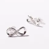 Par de aros plateados con forma de infinito y pequeños cristales incrustados.