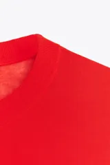 Top de punto color rojo, de cuello redondo y manga larga.