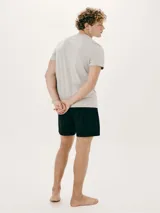 Pijama de dos piezas compuesto por remera manga corta gris con cuello en V y bordado de logo en el pecho, y short negro.