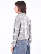 Polerón de tejido de punto color verde militar, con cuello alto y corte holgado.