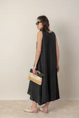 Vestido midi marrón de tejido tramado, corte suelto, sin mangas y con bolsillos laterales.