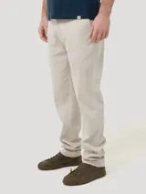 Pantalón de gabardina color beige, corte recto, con bolsillos laterales y traseros. Se ajusta a la cintura con botón y cierre.