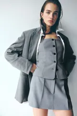 Short pollera corto de sastre color gris, con pinzas frontales, pretina ancha con cierre y corchetes, y bolsillos al bies.