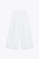 Pantalón culotte negro de tiro medio con cintura elástica y bolsillos laterales ocultos en la costura.