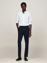 Camisa celeste de corte slim fit con microestampado, cuello abotonado, mangas largas con puños redondeados y logo de Tommy Hilfiger bordado en el pecho.