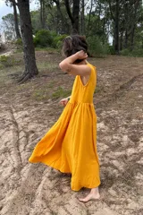 Vestido midi color mostaza, de muselina 100% algodón, con corte holgado y sin mangas.