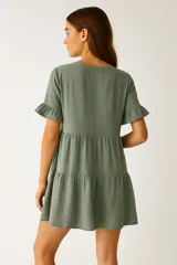 Vestido corto de viscosa color rosado, con escote en V, mangas cortas con volados y corte holgado con frunces en el torso y falda.