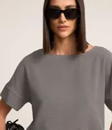 Blusa de crepé con estampado geométrico en blanco y negro, escote redondo y mangas cortas con detalle de doblez.