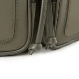 Mochila verde de poliéster con solapa y sujetador. Tiene dos bolsillos externos con cierre, un bolsillo interno con cierre y dos bolsillos internos abiertos. La correa es regulable y los herrajes son plateados. El interior es de tela de algodón y poliéster.