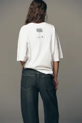 Camiseta blanca de algodón, corte boxy fit, cuello redondo, manga corta y etiqueta contrastante en la espalda.