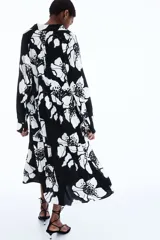 Vestido camisero midi de viscosa con estampado floral en blanco y negro, cuello camisero, tapeta de botones oculta, mangas raglán largas con puños sencillos y costuras fruncidas en la pollera.