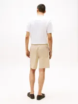 Bermuda de algodón color beige, corte amplio, con cintura elástica ajustable con cordón y bolsillos laterales.