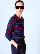 Cardigan azul marino con rayas horizontales rojas, cuello redondo y cierre frontal con botones.