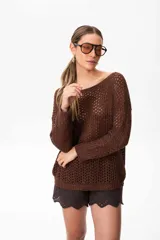 Sweater marrón de tejido calado con lurex en cuello, puños y ruedo. El escote puede usarse de dos formas: mostrando un hombro o de forma clásica.