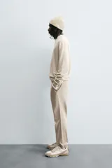 Pantalón jogger negro de corte slim fit, confeccionado en tejido de algodón con cintura elástica ajustable con cordón, bolsillos frontales y traseros de vivo, y bajo con puño elástico.