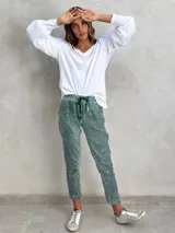 Pantalón de viscosa verde con textura arrugada, corte recto y cintura con cordón ajustable.