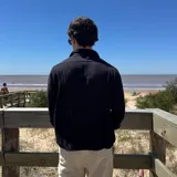 Camisa de manga larga color blanco, con textura de lino arrugado, cuello camisero y botones frontales.