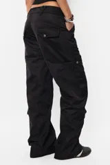 Pantalón cargo color arena, de corte recto y tiro bajo. Cuenta con cierre de nylon y botón personalizado, presillas dobles en la cintura y múltiples bolsillos laterales y traseros con tapa y botón a presión.