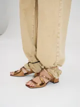 Sandalias de cuero charol color borgoña con tiras finas, taco cuadrado bajo y cierre con hebilla en el tobillo. Interior con estampado del logo de la marca en color naranja.