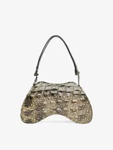 Bolso de hombro con forma estructurada y asimétrica, estampado con la boca abierta de un tiburón en tonos blancos, rojos y azules. Posee un asa ajustable y un pequeño logo metálico frontal.