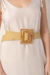 Cinto beige elástico con hebilla cuadrada de ratán.