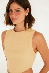 Top color beige, corte crop, con escote redondo y tirantes anchos.