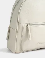 Mochila negra de cuerina con bolsillo frontal con cierre, correas regulables, manija superior, cierre superior y tag de metal.
