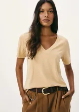 Remera de algodón color beige, con escote en V y mangas cortas.