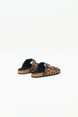 Sandalia tipo birkenstock de pelo con estampado animal print (leopardo), con dos tiras ajustables con hebillas negras y tachas metálicas negras. La plantilla es de corcho y la suela de goma eva.