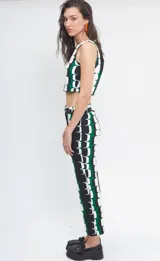 Pantalón de crepé con estampado geométrico en verde, blanco y negro. De corte recto y tiro medio/alto con pretina con cierre y botón.