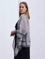 Conjunto de vestido negro sin mangas y chaqueta estampada con terminación asimétrica, marca Sandra Darren.
